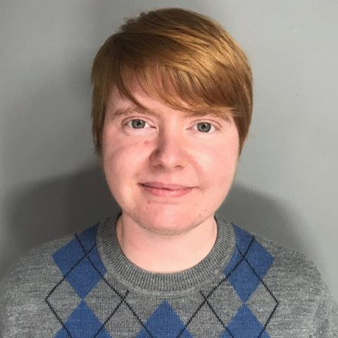 a picture of Maxwell Hope who has short red hair and a sweater on